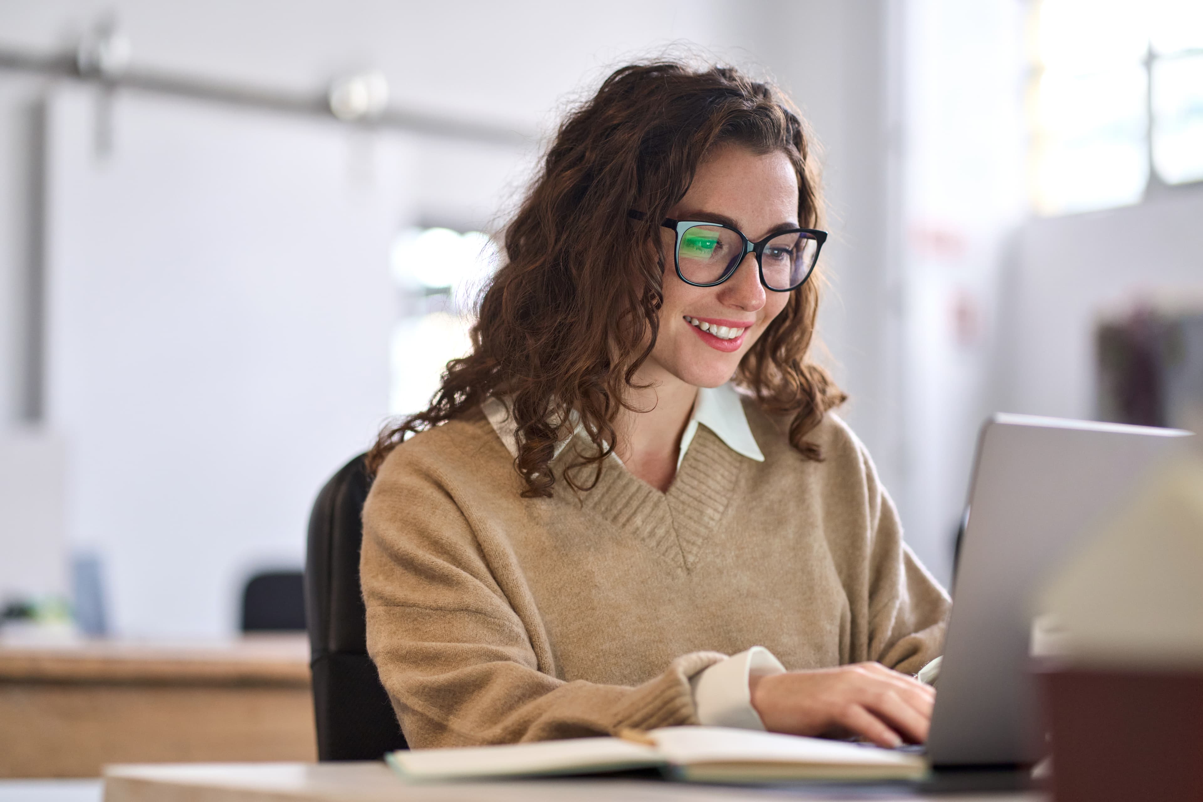 A student studying intently at a desk with books and notes
