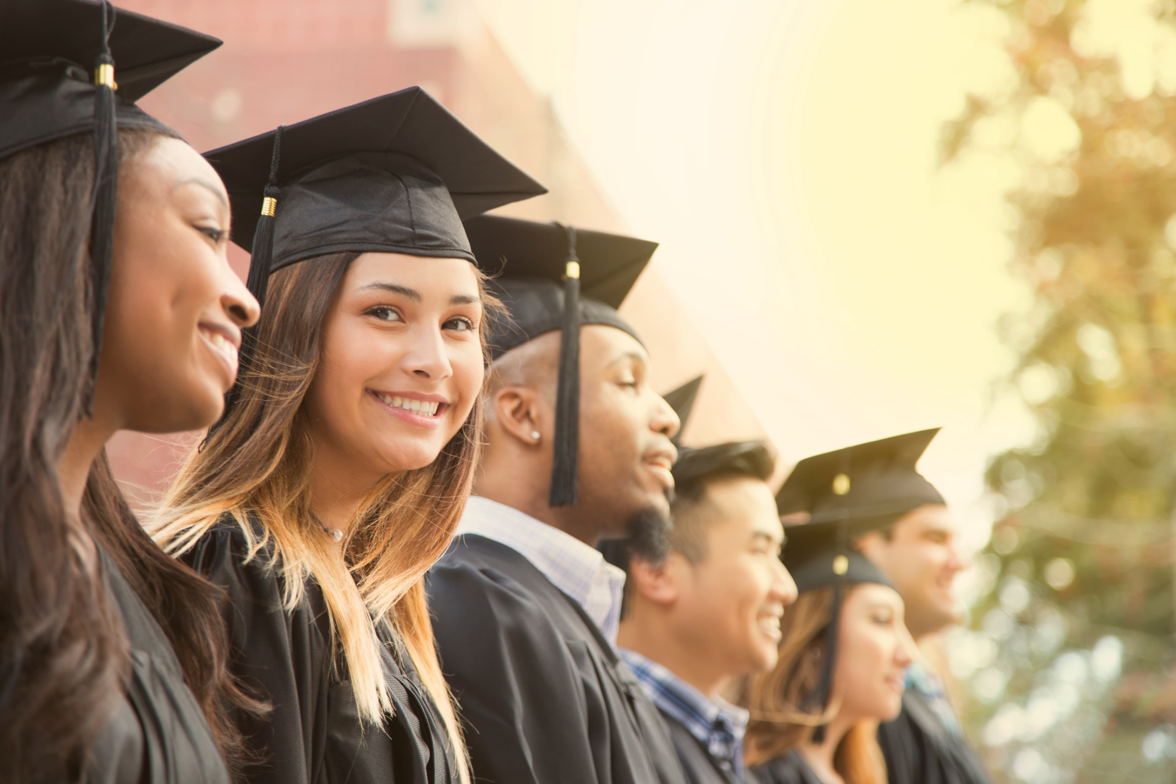 Graduates in caps and gowns, smiling