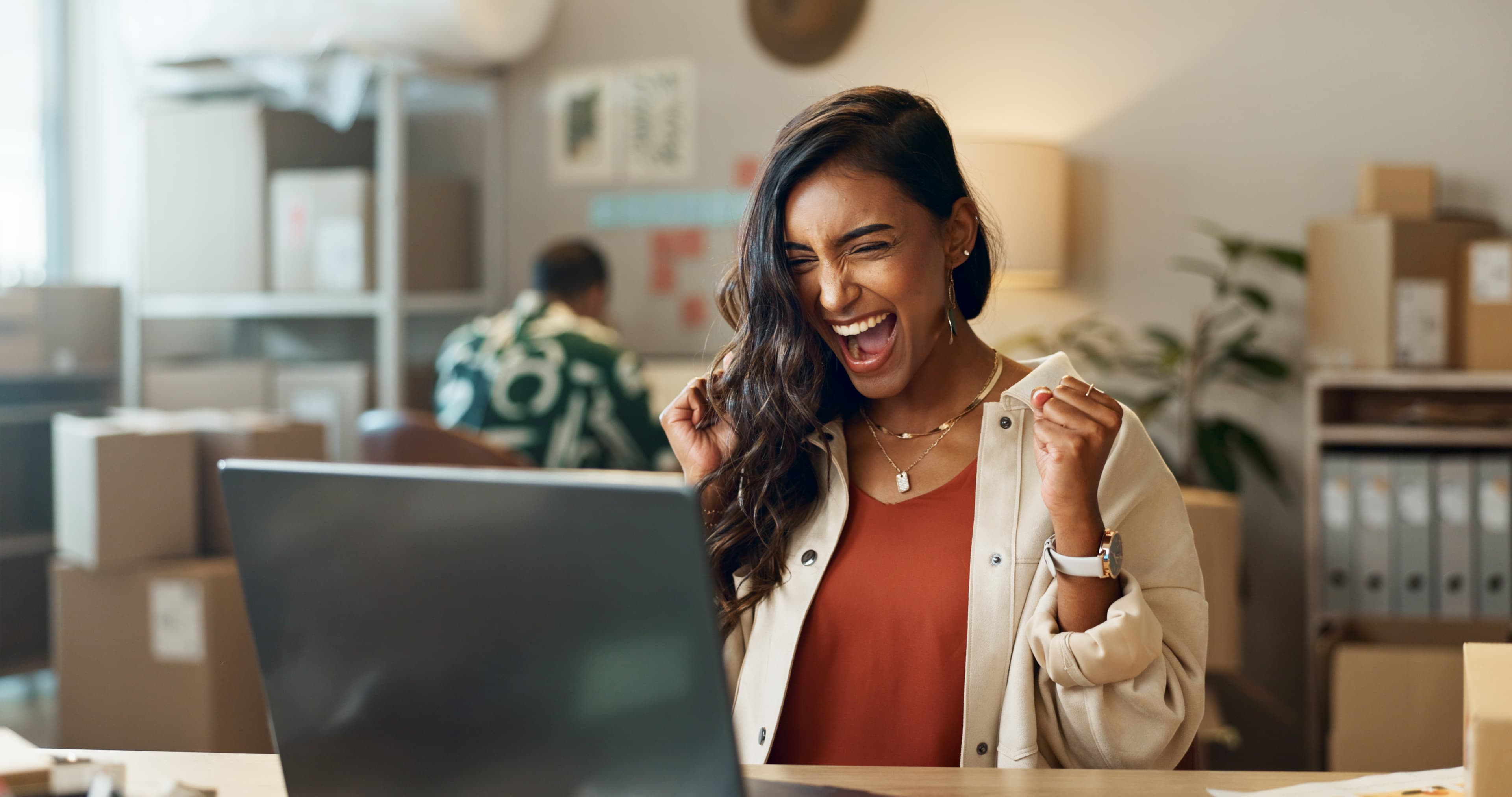 A student celebrating a result on her laptop