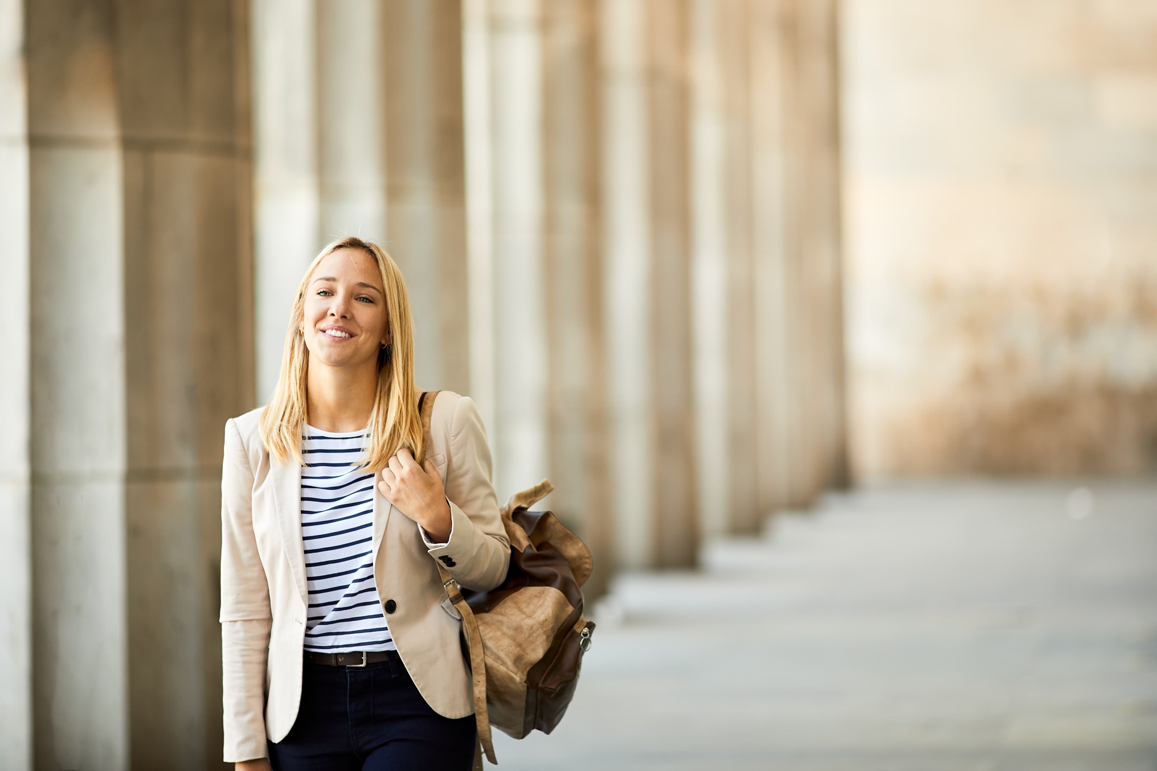 A young woman walking past courthouse columns